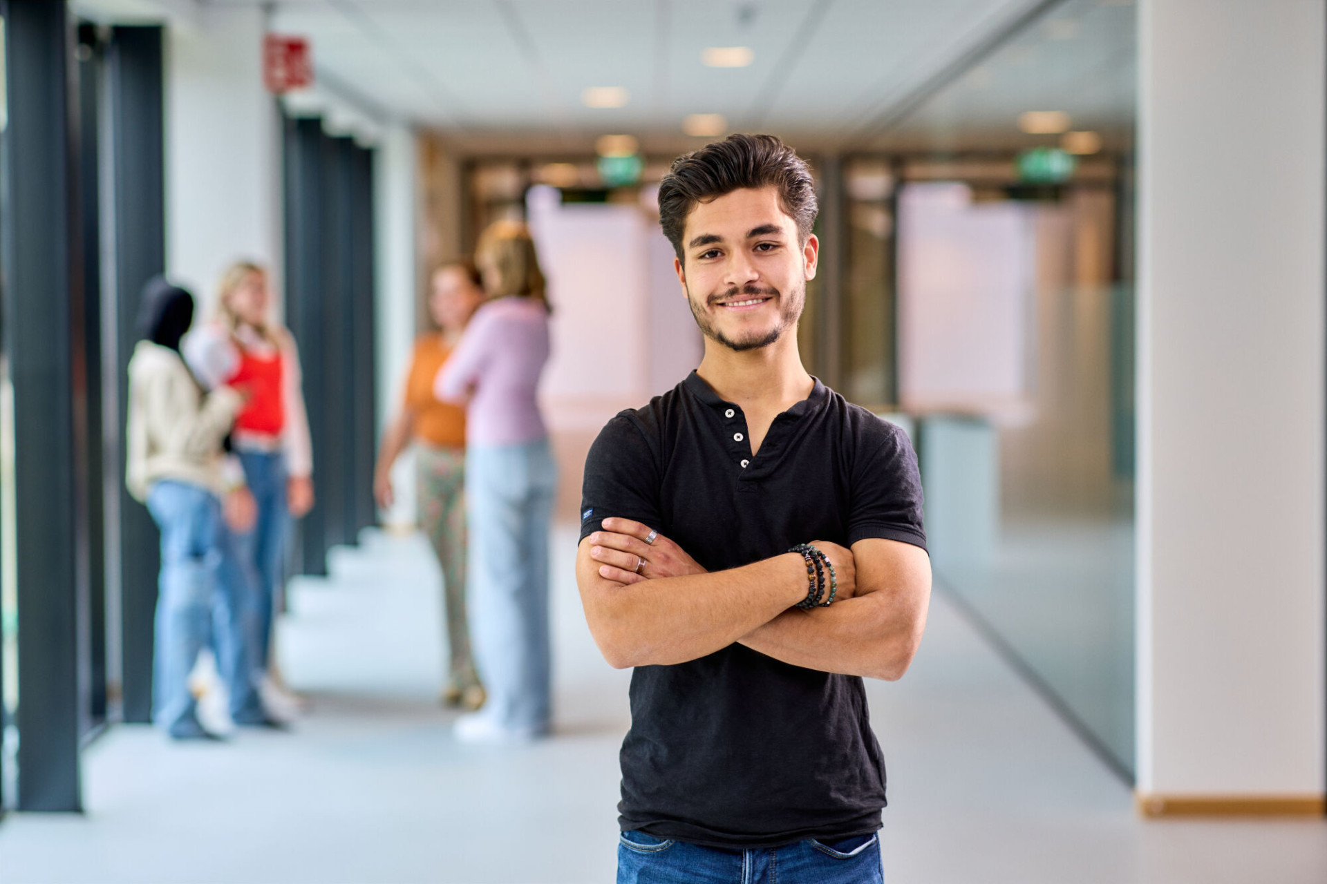 student staat in de gang en kijkt naar camera