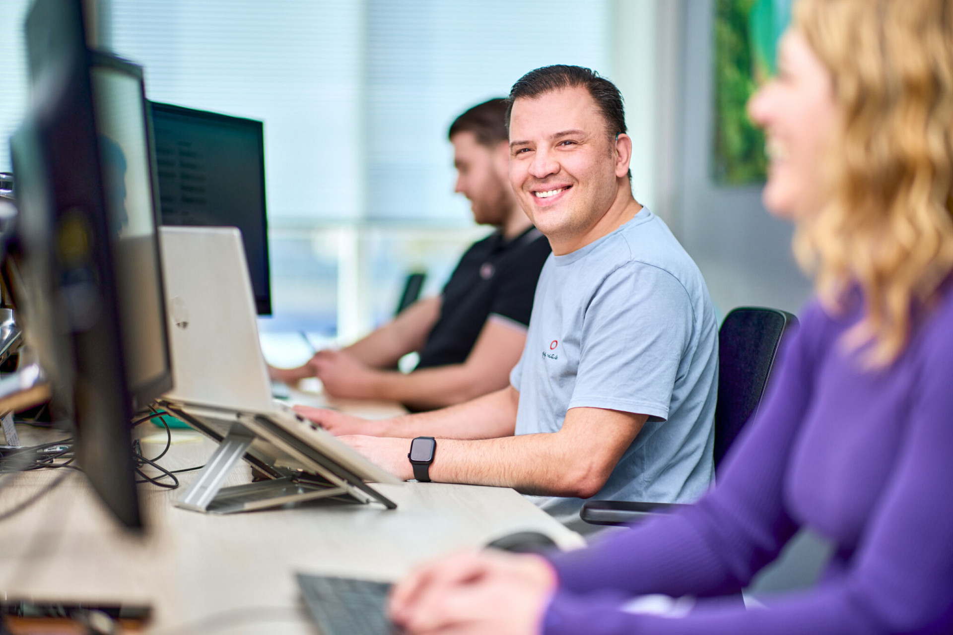 medewerker kijkt tijdens werken achter een computer in de camera